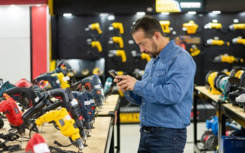 man shopping at a hardware store and taking a photo of the tools - home decoration stock pictures, royalty-free photos & images