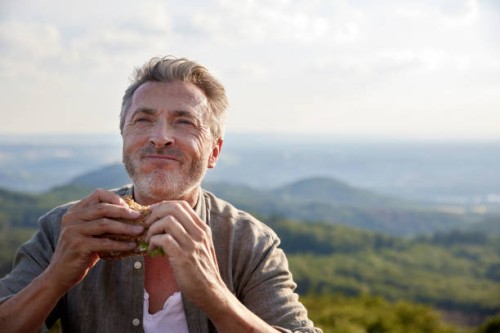 man smiling while holding sandwich - food stock pictures, royalty-free photos & images
