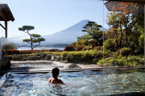 man soaking in an indoor hot spring pool - travel stock pictures, royalty-free photos & images