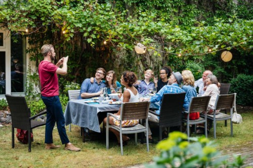 man taking photo of family having lunch outdoors - garden decoration photos et images de collection