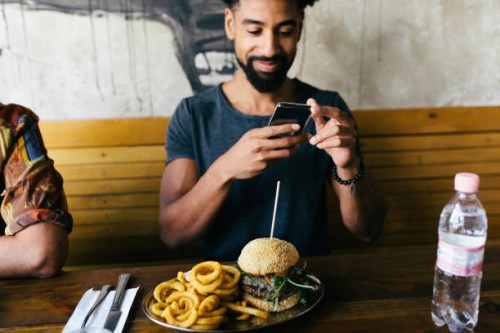 man taking photos of burger with smartphone - food stock pictures, royalty-free photos & images