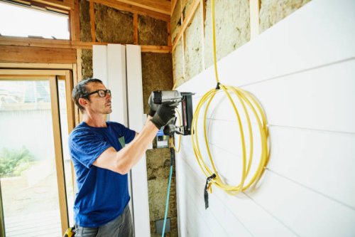 man using nail gun to install siding during home remodeling project - home decoration stock pictures, royalty-free photos & images