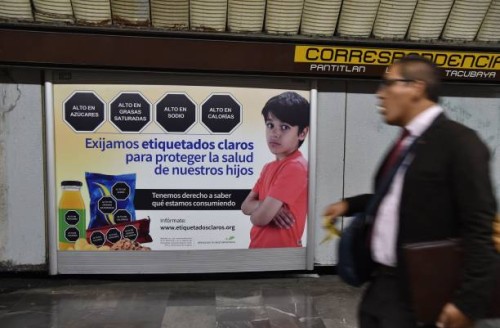 Man walks past a sign that refers to the labeling of products, in the subway of Mexico City, on October 01, 2019. - The Mexican Congress discusses...
