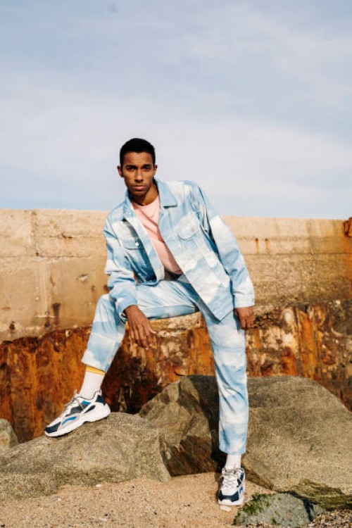 man wearing clouds denim suit staring while standing on stone - fashion stock pictures, royalty-free photos & images