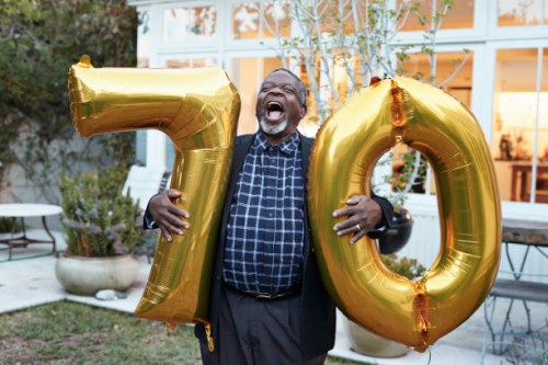 man with number 70 balloons laughing in backyard - garden decoration stock pictures, royalty-free photos & images