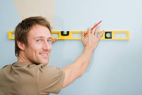 man with spirit level - home decoration stock pictures, royalty-free photos & images