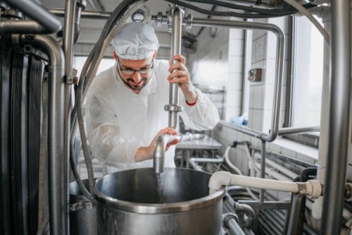 man working at a dairy factory - food stock pictures, royalty-free photos & images