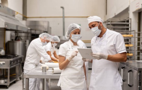 manager talking to a woman working at an industrial bakery - food stock pictures, royalty-free photos & images