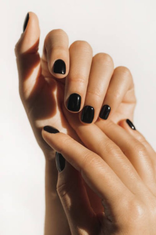 manicure on female hands with black nail polish. - nails art stock pictures, royalty-free photos & images