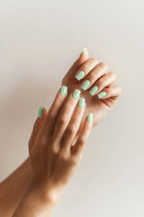 manicure on female hands with trendy green color of the year, pantone nail polish. - nails art stock pictures, royalty-free photos & images