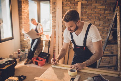 manual worker making measurements on a piece of wood at construction site. - home decoration stock pictures, royalty-free photos & images