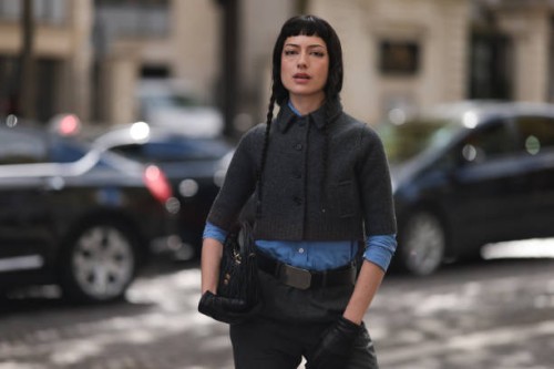 Maria Bottle is seen wearing a complete outfit from Miu Miu, consisting of a grey cropped jacket with ribbed trims, a black button placket, and a...