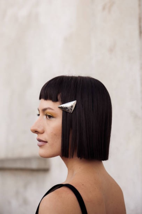 Maria Bottle wears Prada hair clips, a black Prada bra, a black low waist micro skirt, and a black bag outside Prada during the Milan Fashion Week -...