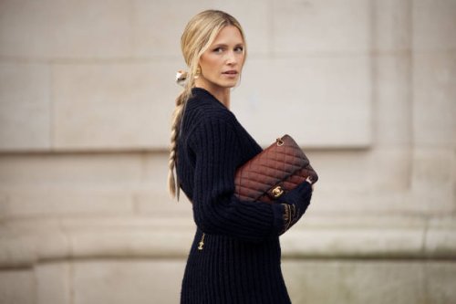 Maria Helena Bordon Meireles wears blue knitted top, brown Chanel belt, Brown Chanel bag, gold Chanel necklace outside the Chanel show during...