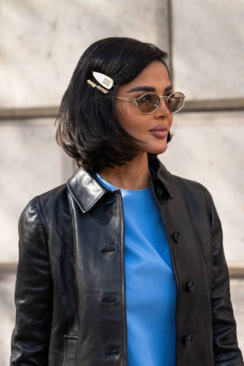 Mariam Mohammad wears a Miu Miu jacket, dress, sunglasses and hair clips outside the Miu Miu show during Womenswear Spring/Summer 2025 as part of...