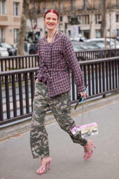 Marianne Theodorse wears pink tweed jacket, military print pants, sequins Chanel bag, pink heels, outside Chanel, during the Womenswear Fall/Winter...