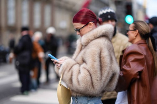 Marianne Theodorsen wears sunglasses, golden earrings, a brown / beige fluffy oversized faux fur winter coat, outside The Garment, during the...