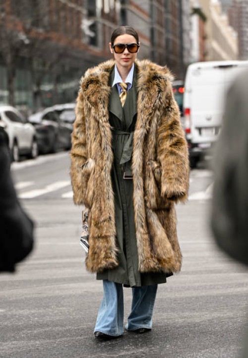 Marina Ingvarsson is seen wearing a tan faux fur coat, green coat, blue jeans and black sunglasses outside the Michael Kors show during NYFW F/W 2025...