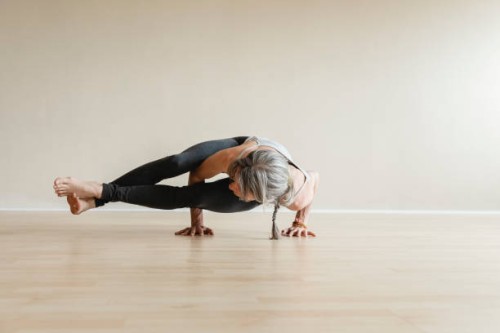 master yoga woman doing eight-angle pose, astavakrasana. - fashion stock pictures, royalty-free photos & images