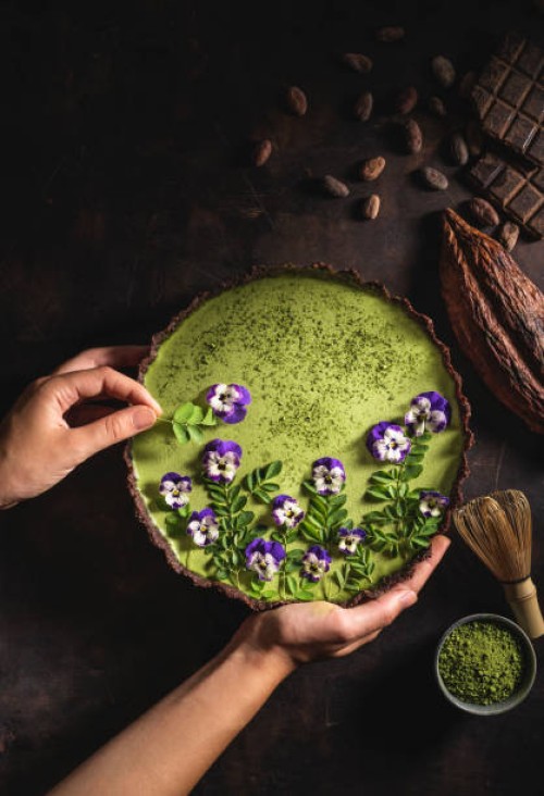 matcha tea and chocolate superfood tart moringa and pansy flowers - food stock pictures, royalty-free photos & images