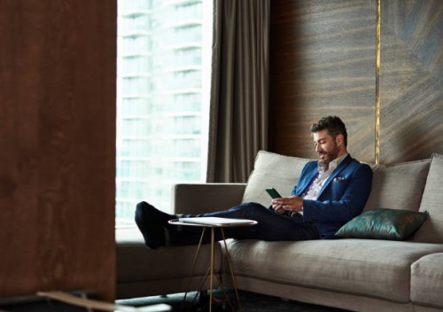 mature businessman texting on phone in hotel room - travel stock pictures, royalty-free photos & images