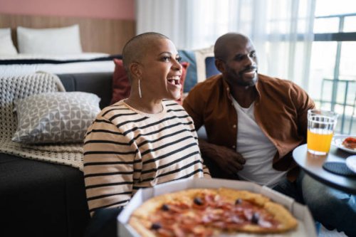 mature couple eating pizza and watching tv at home - junk food stock pictures, royalty-free photos & images