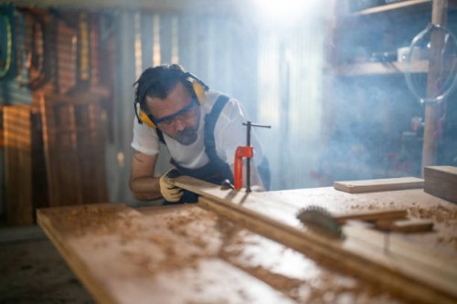 mature man cutting wood in workshop - home decoration stock pictures, royalty-free photos & images