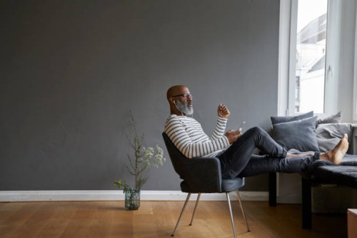 mature man sitting with feet up, using smartphone - fashion photos et images de collection