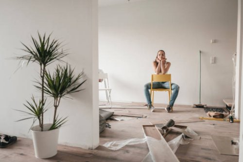 mature woman moving house, sitting on chair - home decoration stockfoto's en -beelden