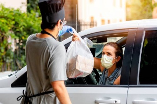 mature woman picking her restaurant food from her car at a pick up curve - junk food stock pictures, royalty-free photos & images