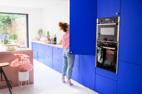 medio volwassen kaukasische vrouw die in koelkast bereikt - home decoration stockfoto's en -beelden