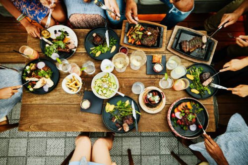 medium overhead shot of families sharing dinner at outdoor restaurant - food stock pictures, royalty-free photos & images