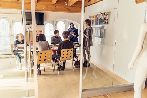 meeting in small creative start-up enterprise lead by woman. - fashion stock pictures, royalty-free photos & images