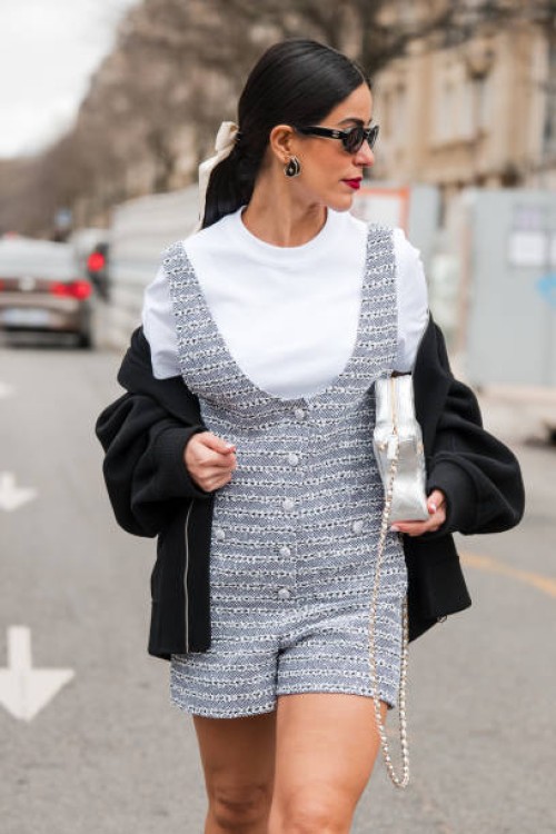 Mehrnaz Ansari wears white t-shirt, grey tweed playsuit, black sweatshirt, silver Chanel bag, outside Chanel, during the Womenswear Fall/Winter...