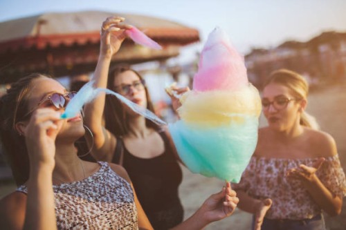 meisjes suikerspin eten op de kermis - food stockfoto's en -beelden