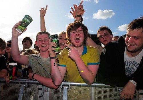 Members of the crowd pose with pints of lager during a concert at the Reading Festival on August 29, 2009 in Reading, England.