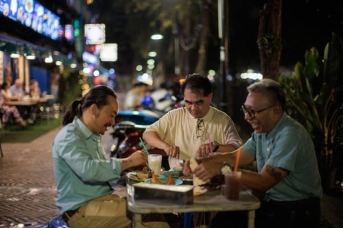 men eating authentic thai food at the night market - junk food stock pictures, royalty-free photos & images