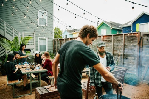 men grilling food for friends during backyard barbecue - garden decoration photos et images de collection