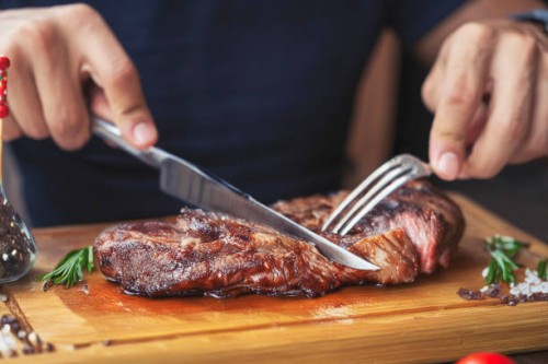 men's hands holding knife and fork, cutting grilled steak - food stock pictures, royalty-free photos & images