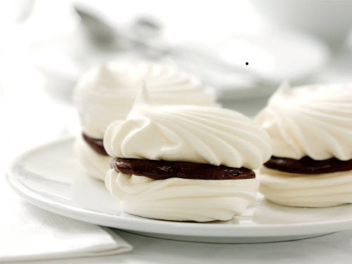 meringue biscuits with chocolate filling on plate - junk food stockfoto's en -beelden