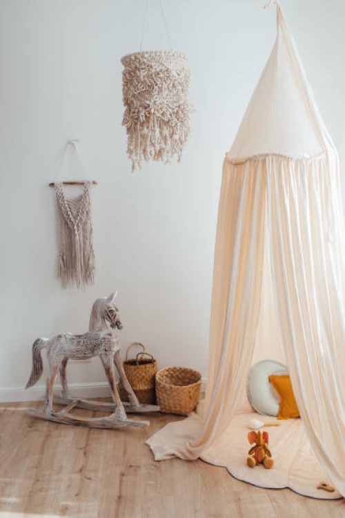 messy children's playroom full of toys. beautiful decoration nursery with natural macrame decoration, organic canopy, wicker baskets and wood toys. vertical photo. - home decoration stock pictures, royalty-free photos & image
