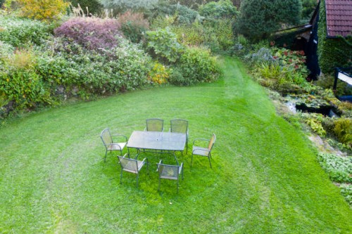 metal table and chairs on lawn; veddw house garden, october, autumn. image taken from drone. - garden decoration photos et images de collection