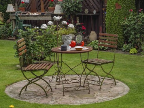 metal table and two chairs on a stone slab in the garden, decorated with a bust and small lamps, borken, münsterland, germany - garden decoration stock pictures, royalty-free photos & images