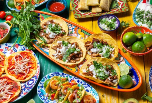 mexican independence day table, food for independencia -chiles en nogada, tacos al pastor, chalupas pozole, tamales, chicken with mole poblano sauce. yellow and green wooden background - food stock pictures, royalty-free phot