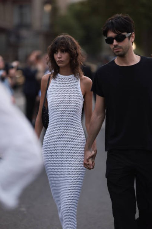 Mica Arganaraz is seen wearing Alaia white net dress, Alaia black leather sandals and a black shoulder bag outside Alaia show during the Haute...