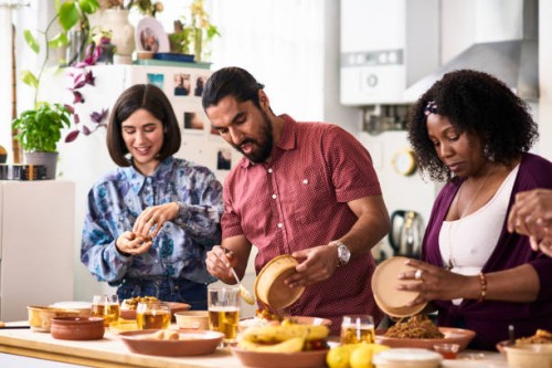 mid adult man and two female friends serving takeaway food at home - junk food stock pictures, royalty-free photos & images
