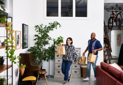 mid adult man and woman bringing takeaway food home - junk food stock pictures, royalty-free photos & images