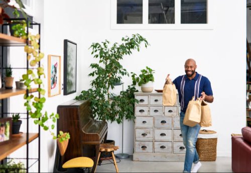 mid adult man bringing takeaway food back home - junk food stock pictures, royalty-free photos & images