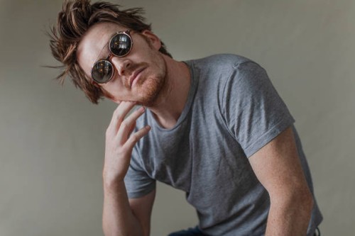 mid adult man with head cocked wearing sunglasses - fashion stock pictures, royalty-free photos & images