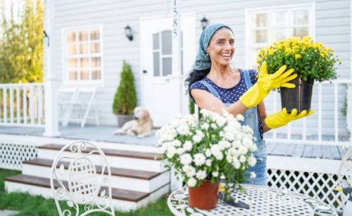 mid adult woman planting flowers in front of a porch - garden decoration stock pictures, royalty-free photos & images